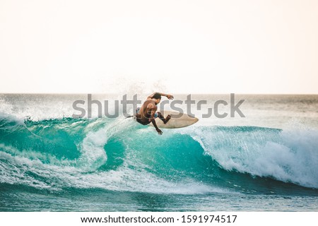 professional surfer riding waves in Bali, Indonesia. men catching waves in ocean, isolated. Surfing action water board sport. people water sport lessons and beach swimming activity on summer vacation Foto d'archivio © 