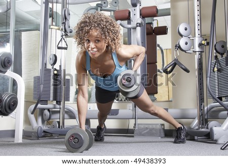 Woman working out with weights in a gym