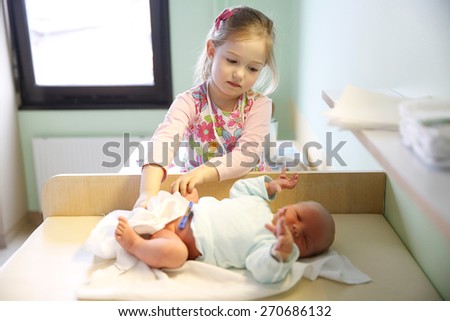 Newly made sister with her newborn brother in hospital maternity ward just before leaving for home.