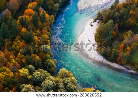 Pristine alpine turquoise river meandering through forested landscape in a sunny autumn day, aerial view. Pristine, clean nature, pure water, environment concept.
