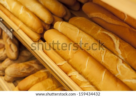 Tasty french baguettes arranged in rows in bakery/French Baguette in bakery store