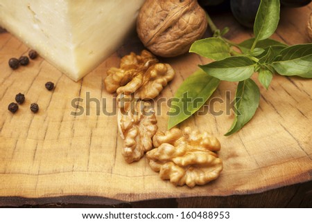 Walnuts and cheese/Organic walnuts and hard cheese on old wooden stump. Still life. Food arrangement on wooden background. Organic healthy food.