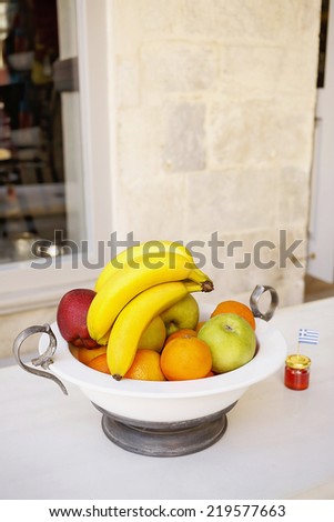 Fruit in deep plate, bananas, apples and oranges, honey.Very shallow depth of field/Fruits