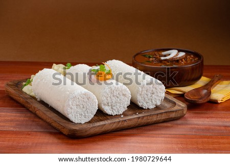 Puttu,Raw rice puttu,Arisi Maavu Puttu with chana or Bengal gram curry _breakfast items made using raw rice flour, an ideal combination arranged in a brown wooden base 