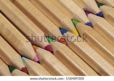 Wooden colored pencils arranged to form a zigzag pattern