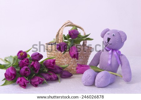 beautiful vintage purple knitted bear with a bouquet of purple tulips and a basket