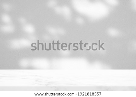 White Marble Table with Tree Shadow in the Garden on Concrete Wall Texture Background, Suitable for Product Presentation Backdrop, Display, and Mock up.