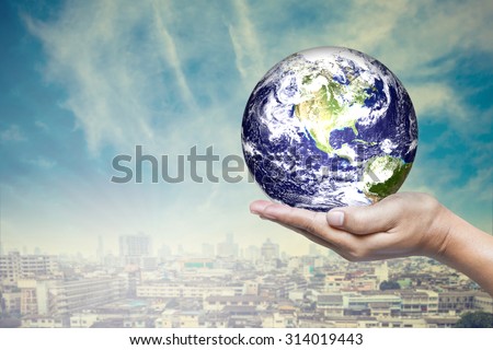 Planet in hand with downtown background, Elements of this image furnished by nasa.