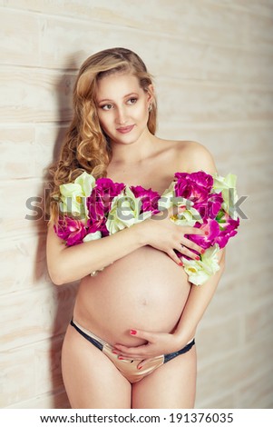 Nude pregnant lady with flowers