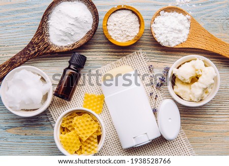 Making homemade deodorant stick with all natural ingredients concept. Blue wooden background. Ingredients: arrowroot powder, baking soda, beeswax, shea butter, essential oil, cornstarch, coconut oil.