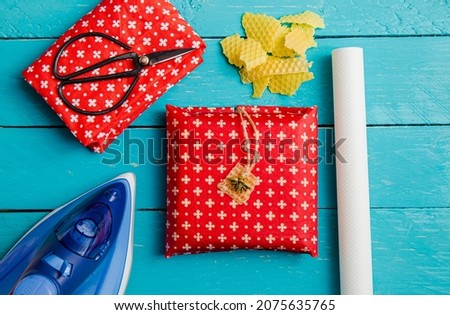 Take away sandwich inside homemade beeswax wraps. Wrapping food in handmade beeswax wrap cloth indoors, alternative for plastic. Using iron machine to melt beeswax into cotton cloth.