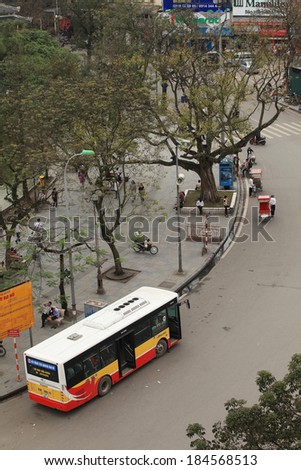 HANOI, VIETNAM - MAR 29, 2014: State owned bus parking on the side of street near Hoan Kiem lake. Hoan Kiem lake area is known as the center of Hanoi capital.