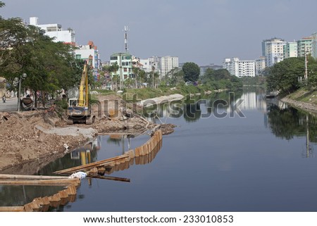 Hanoi, Vietnam - Nov 23, 2014: View of a construction site on a polluted river in a urban area in Hanoi capital.