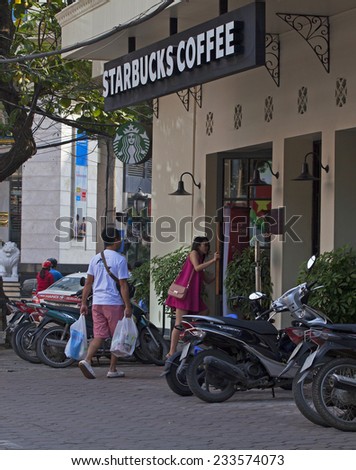 HANOI, VIETNAM - NOV 23, 2014: Customer entering a coffee shop of Starbucks in Hanoi capital. The first store of Starbucks opened in Vietnam in early 2013.