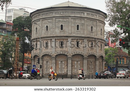 Hanoi, Vietnam - Mar 15, 2015: Vehicles traveling in front of Hang Dau water tower. This tower was built in 1894 in the period of time when French ruled Vietnam.