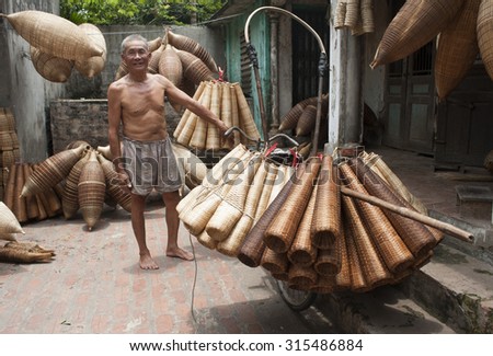 Vietnamese old craftsman making bamboo handicraft products to maintain a traditional handicraft in a countryside of Vietnam. Concept of life in Vietnam.
