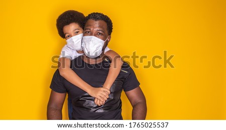 Portrait of  African American father with toddler son using mask. Father and son wearing mask to protect covid 19, quarantine. Stay at home concept. Fathers day! 