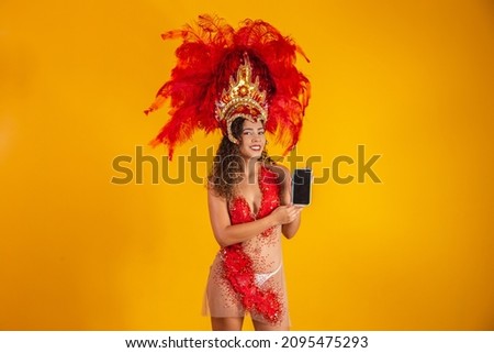 Beautiful young woman in special carnival feather costume holding a smartphone with blank screen with space for text. Virtual carnival, promotion and advertisements.  Foto stock © 
