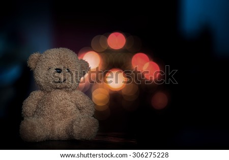 bear toy sitting on old wood and bokeh background