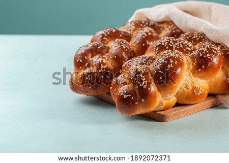 Homemade Challah bread with white cover, Jewish cuisine. Decorated with sesame and poppy seeds. Light green background. Stok fotoğraf © 