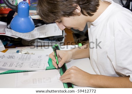 Young student makes technical drawing on a board with their tools