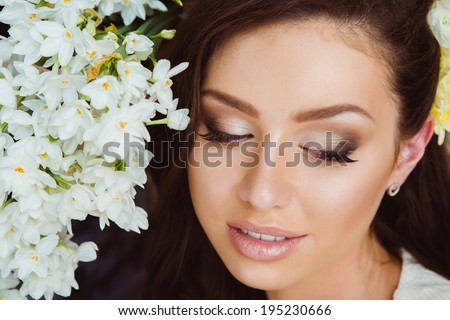 Portrait of Beautiful Young Woman in Flowers. Healthy Long Hair and Clear Skin.