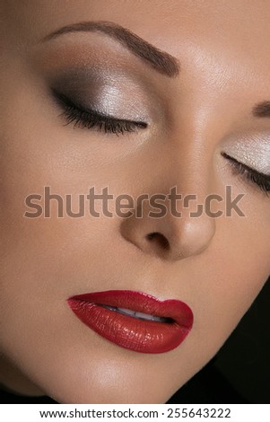 Beauty Close-up Portrait of Beautiful Sexy Woman Model with Gray Fashion Eyes Make-up and Red Lips on Black Background
