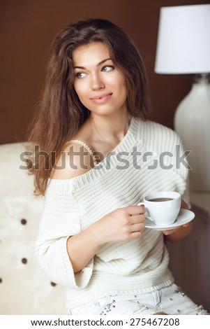 Portrait of Young Woman at Home Sipping Tea from a Cup