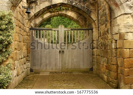 wooden gate under sandstone arches
