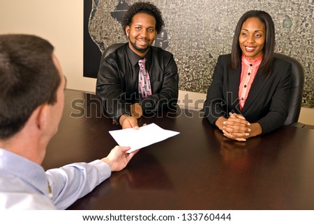 Young African American couple about to sign papers