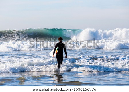 Similar – Image, Stock Photo Surfer entering into the water with his surfboard.