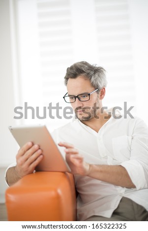 handsome man surfing on tablet on a couch