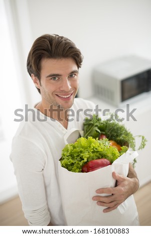 man with a vegetables\'s bag in his arms