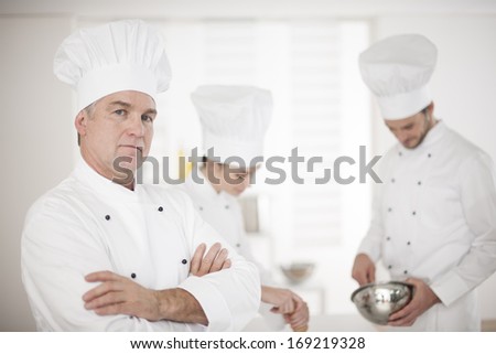 portrait of a chef and his kitchen team