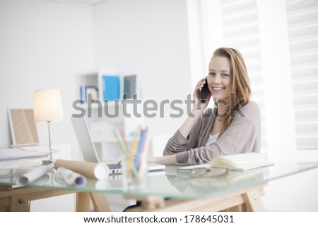 beautiful young woman on the workplace using his phone