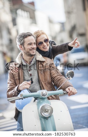 handsome couple riding a trendy scooter