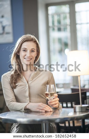 beautiful young woman drinking a wineglass alone in a bar - Stock Image ...