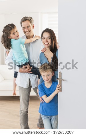 Family standing at front door to invite people at home