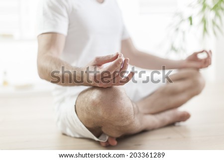 man practicing yoga in the lotus position focus on hand