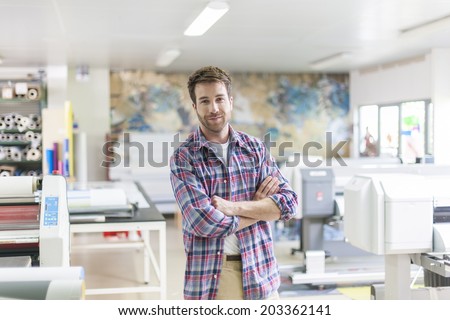 worker in a workshop with machines at the background