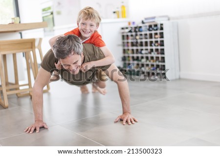 father and son  are doing push ups and having fun  at home