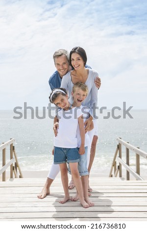 happy family  standing on a wood pontoon in front of the sea in summertime