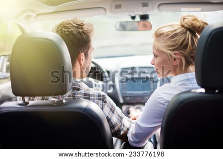 handsome couple doing a car trip, view from rear seat
