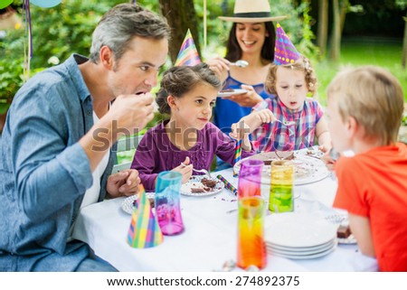 Family sharing the birthday cake. Everybody is enjoying his piece