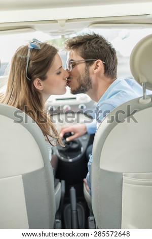 rear view, a lovely couple kissing in a car
