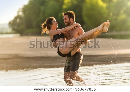 https://image.shutterstock.com/display_pic_with_logo/1946624/360677855/stock-photo-handsome-couple-having-fun-in-the-water-at-the-beach-during-the-holidays-the-man-is-shirtless-and-360677855.jpg