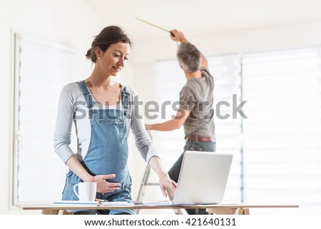 Couple performing renovation work in a house, the woman  