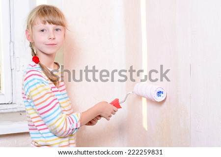 child paints the wall roller