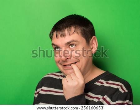 Funny young man is wondering while he pulling his lip downwards with finger