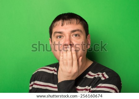 young boy with his mouth and eyes wide and covering her mouth with her hands, expression of surprise, yawning,